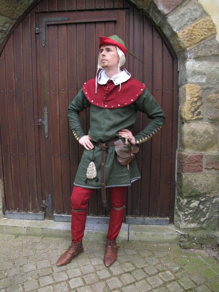 Man in medieval costume in front of a wooden door